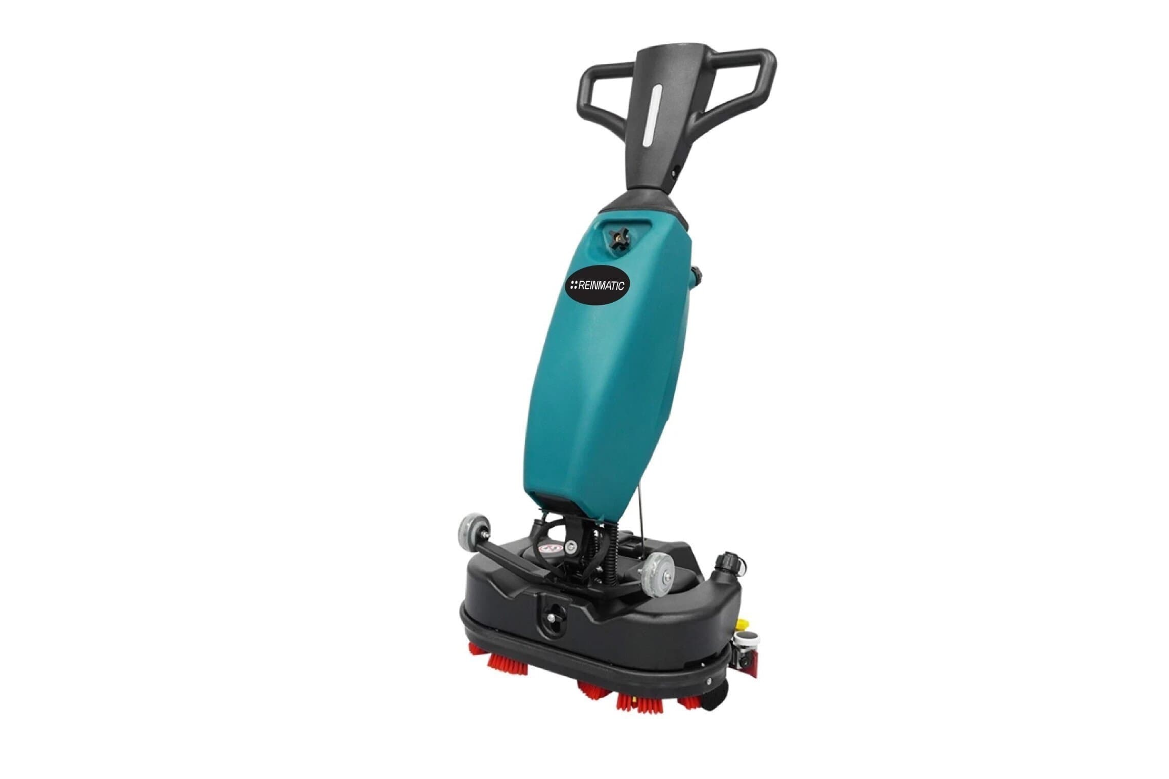 Reinmatic RM 5 compact teal walk-behind scrubber-dryer — three-quarter front studio view showing the REINMATIC badge, tank housing, and red roller brushes on a white background